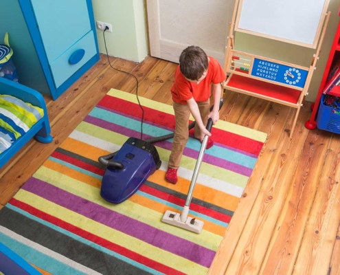 boy vacuuming a rug