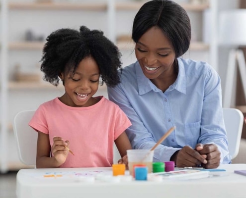 Smiling young girl and a woman painting