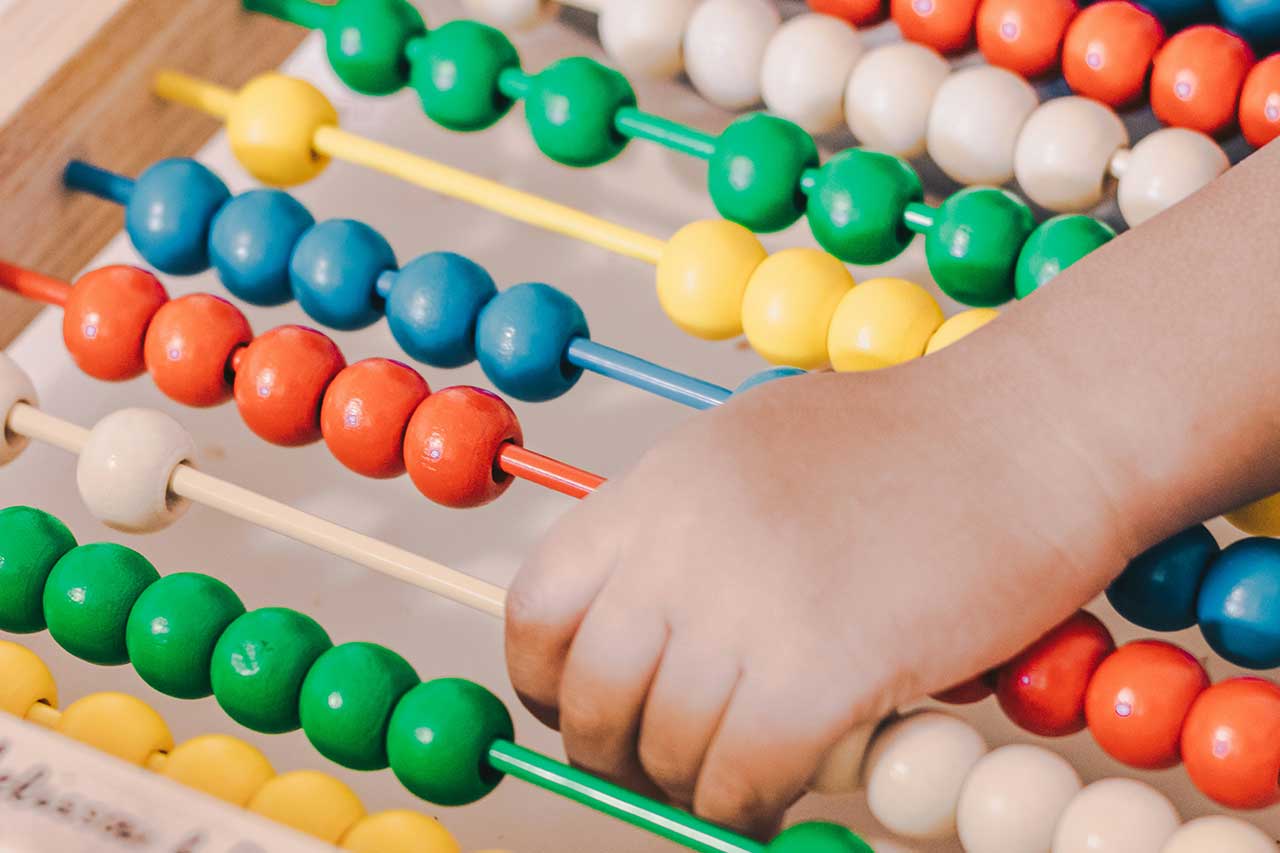child counting on colorful abacus