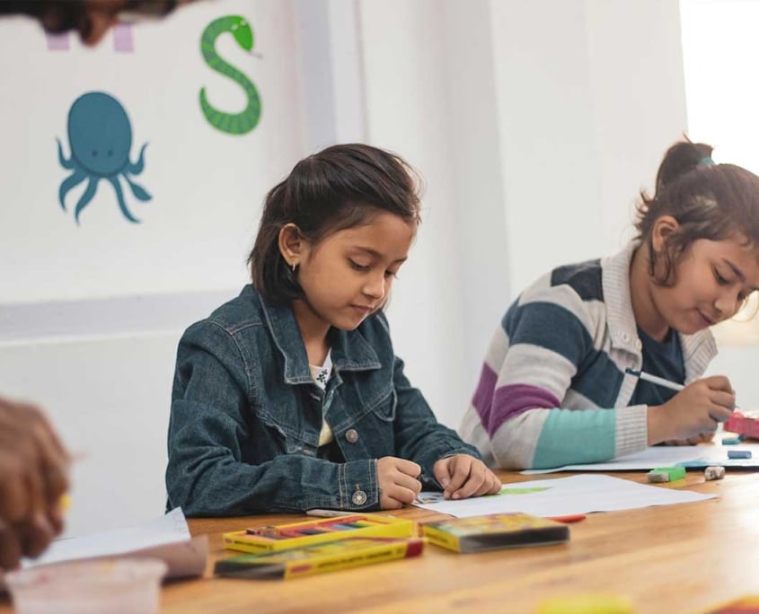 Two girls coloring in a classroom