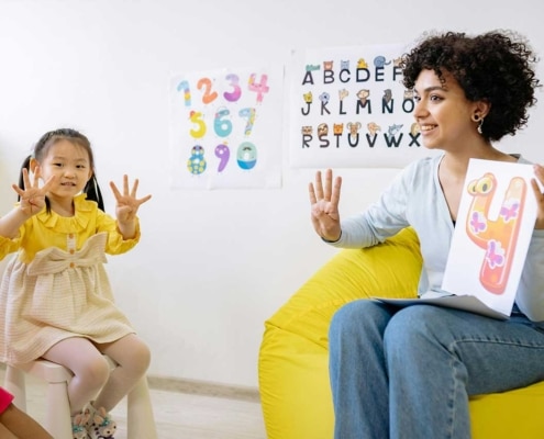 Woman and child showing the number 4 on their hands.