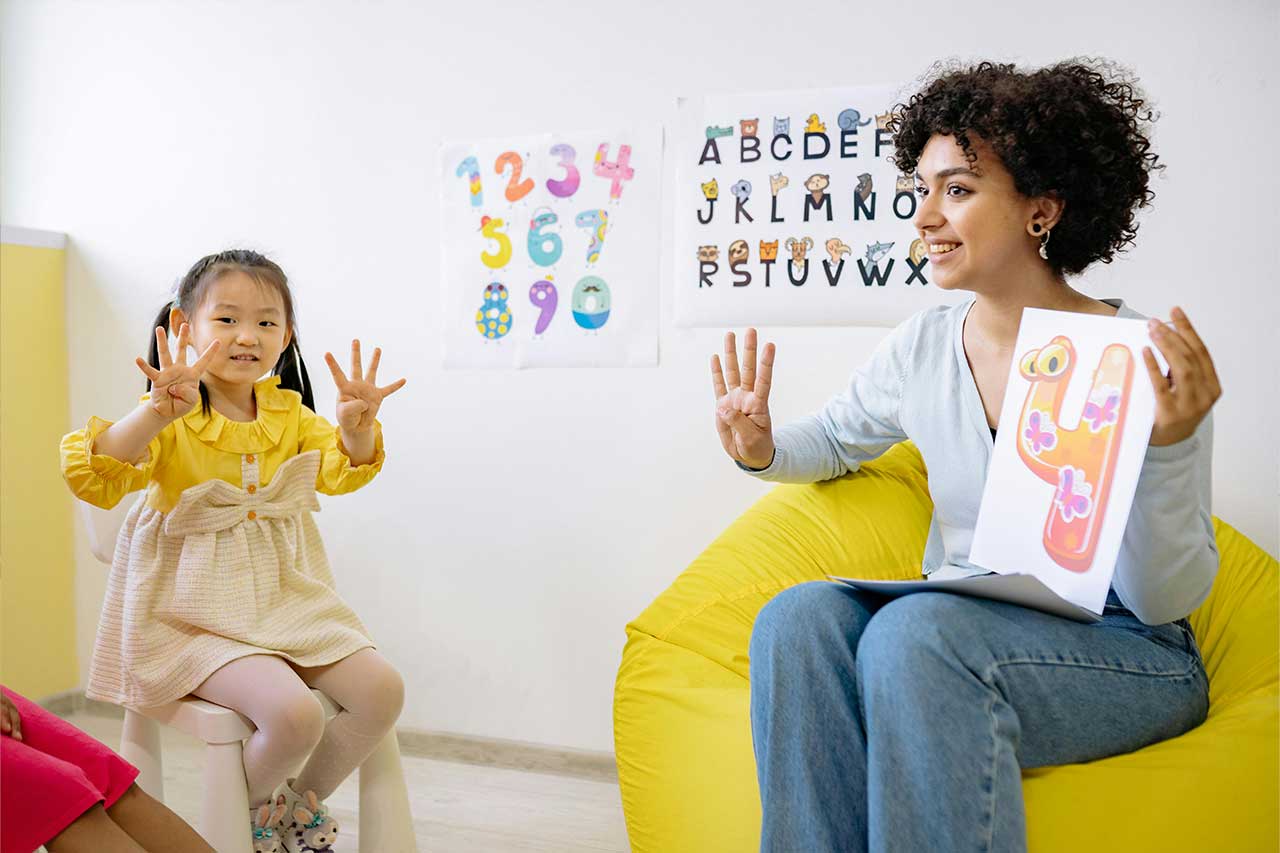 Woman and child showing the number 4 on their hands.