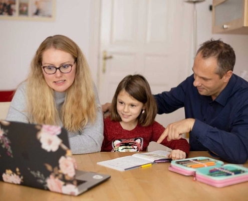 Two adults working to do school work with a child