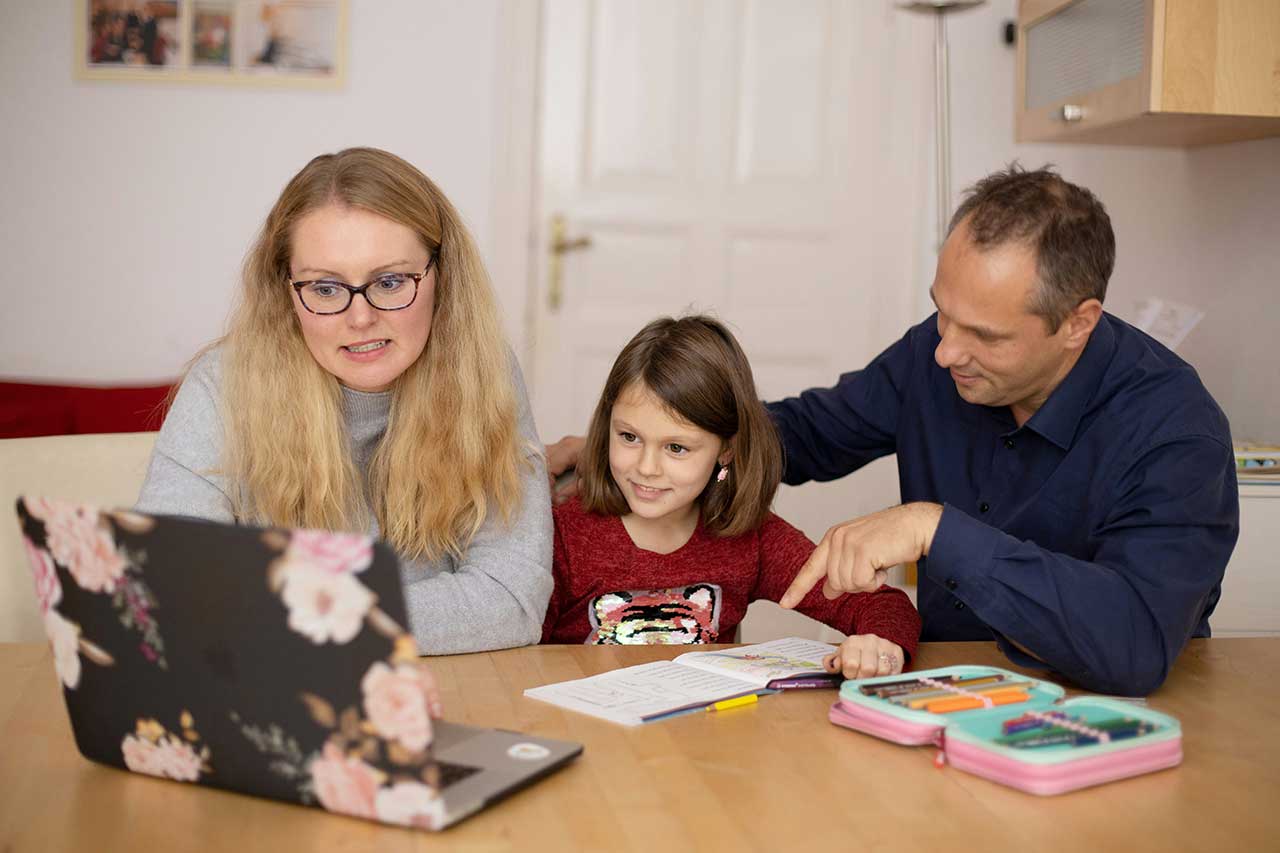 Two adults working to do school work with a child